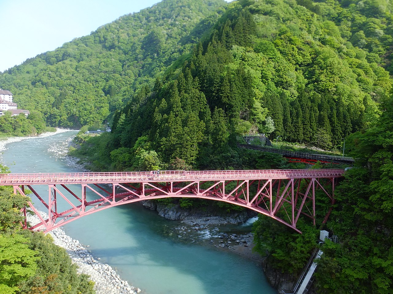 The old Yamabiko red truss bridge over the green Kurobe River