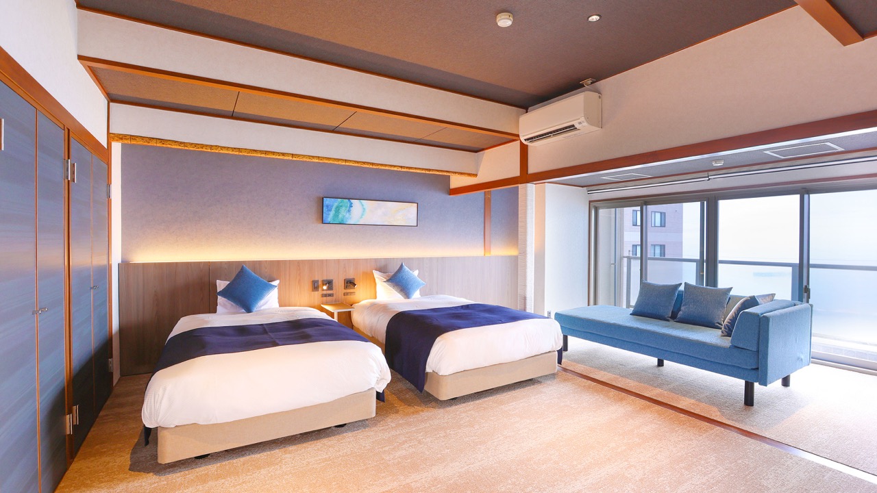 A room with twin beds and a day sofa