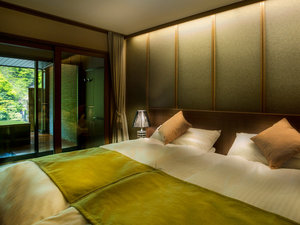 A room with an open-air bath behind glass at Enraku
