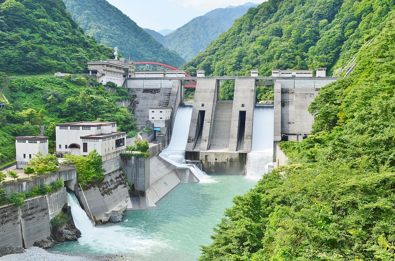 Unazuki Dam and its power station among green hillsides in summer